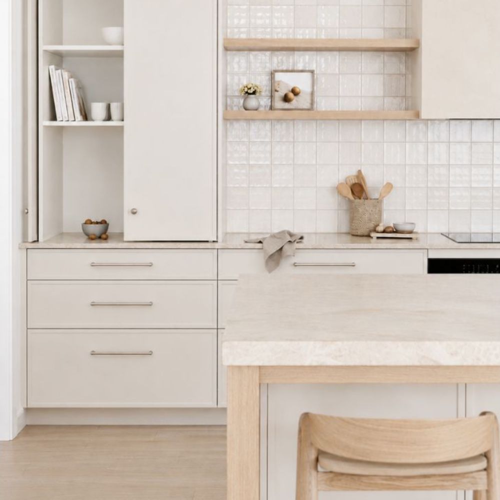 Brushed nickel hardware on warm white cabinetry in a contemporary coastal kitchen